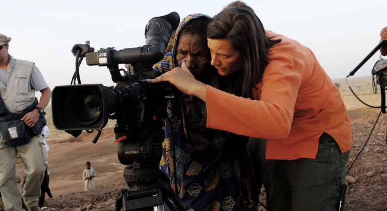 A documentarian and her interview subject look at the screen of the camera