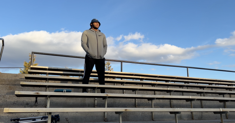 Kevin Couser stands on the bleachers